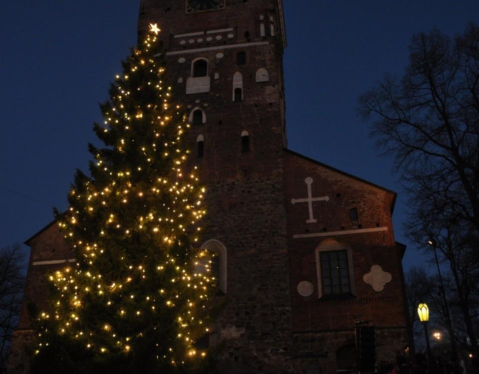 En stor julgran utanför en kyrka.