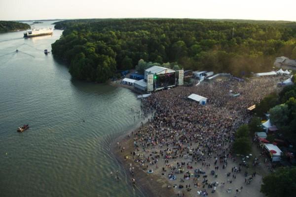 Flygfoto över publikhav och scen vid en strand