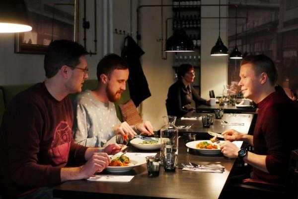 Tre personer sitter vid ett bord på en restaurang