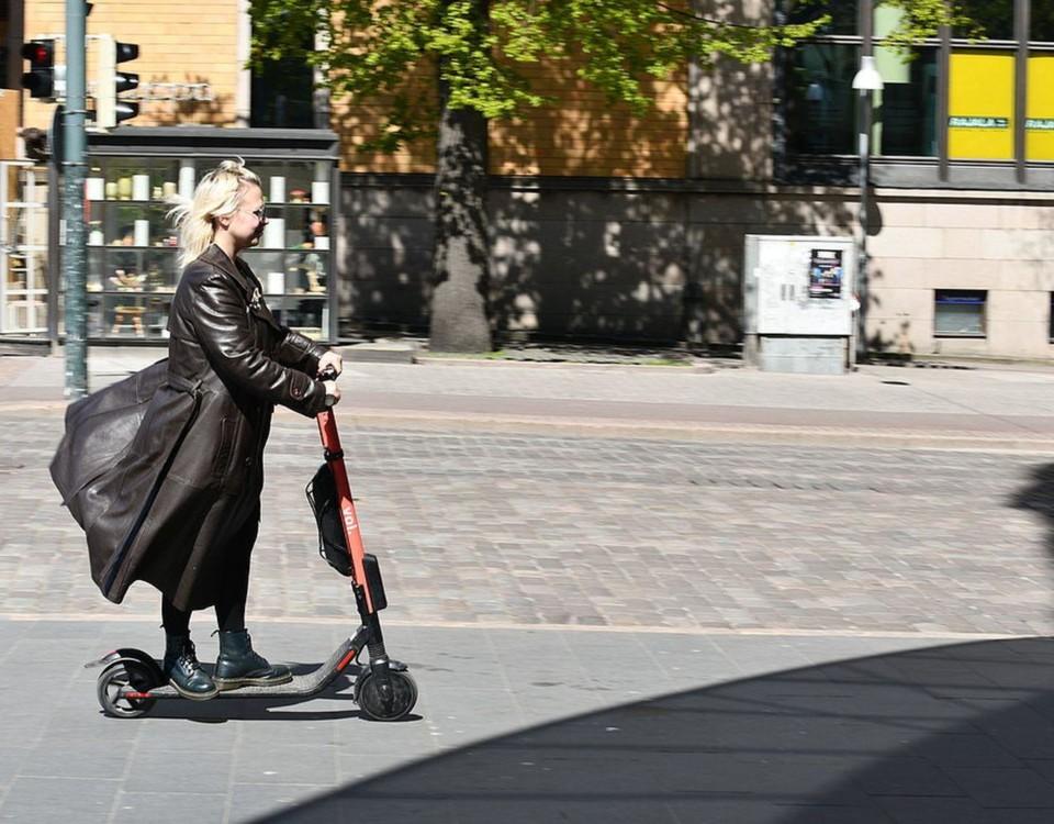 Kvinna åker elsparkcykel.