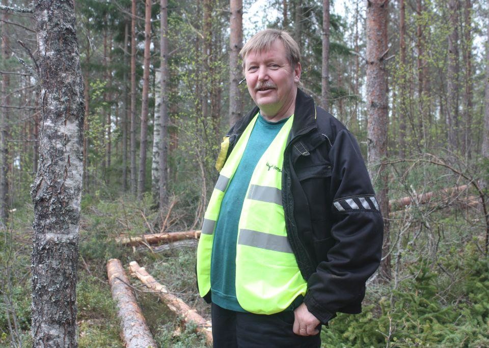 Halvbild på Kenneth Stenberg som ser in i kameran, skog i bakgrunden.