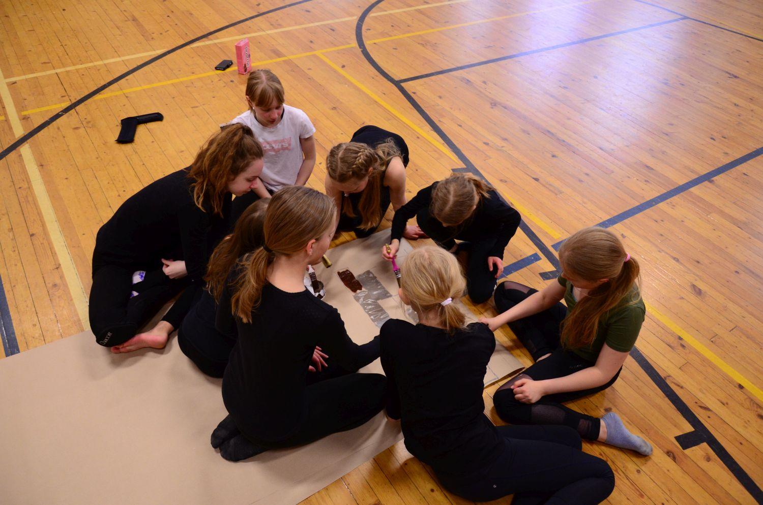 Medlemmarna i gymnastikgruppen Aurora pysslar ihop kulisser för vårfesten.