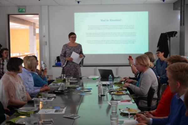 Seminarium om Kimitoöns kommun 10 år i Villa Lande. Människor sitter runt ett bord, kommundirektör Anneli Pahta säger inledningsord.