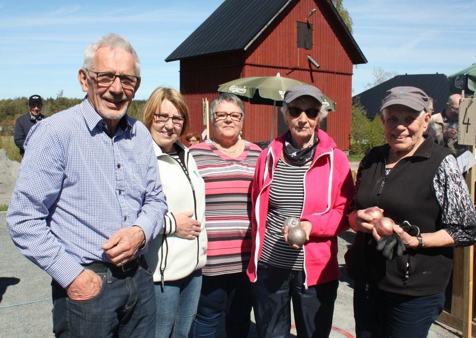 Personer står uppradade på rad utomhus och tittar in i kameran.