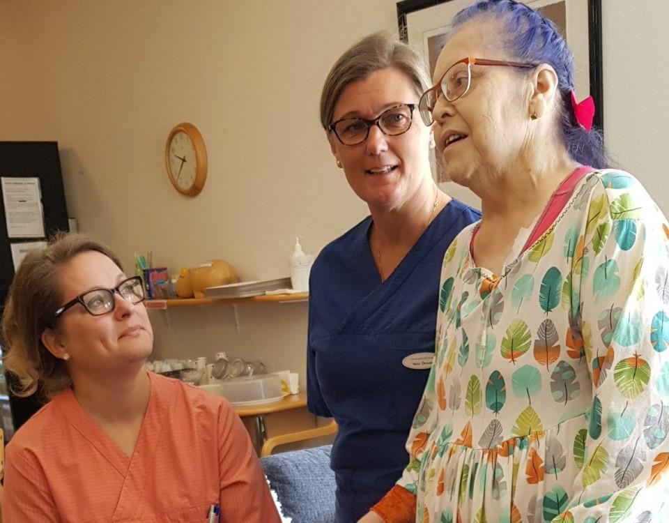 Nina Öhman (tv) och Satu Nurmela, sjukskötare på Karinahemmet i Åbo, tillsammans med patienten Maria Laitakari.