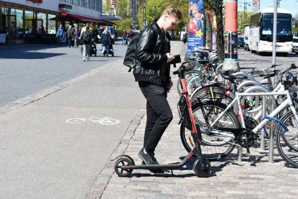 En person vid en elsparkcykel i stan