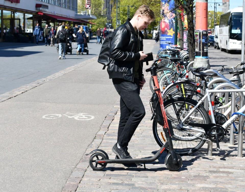 En person vid en elsparkcykel i stan