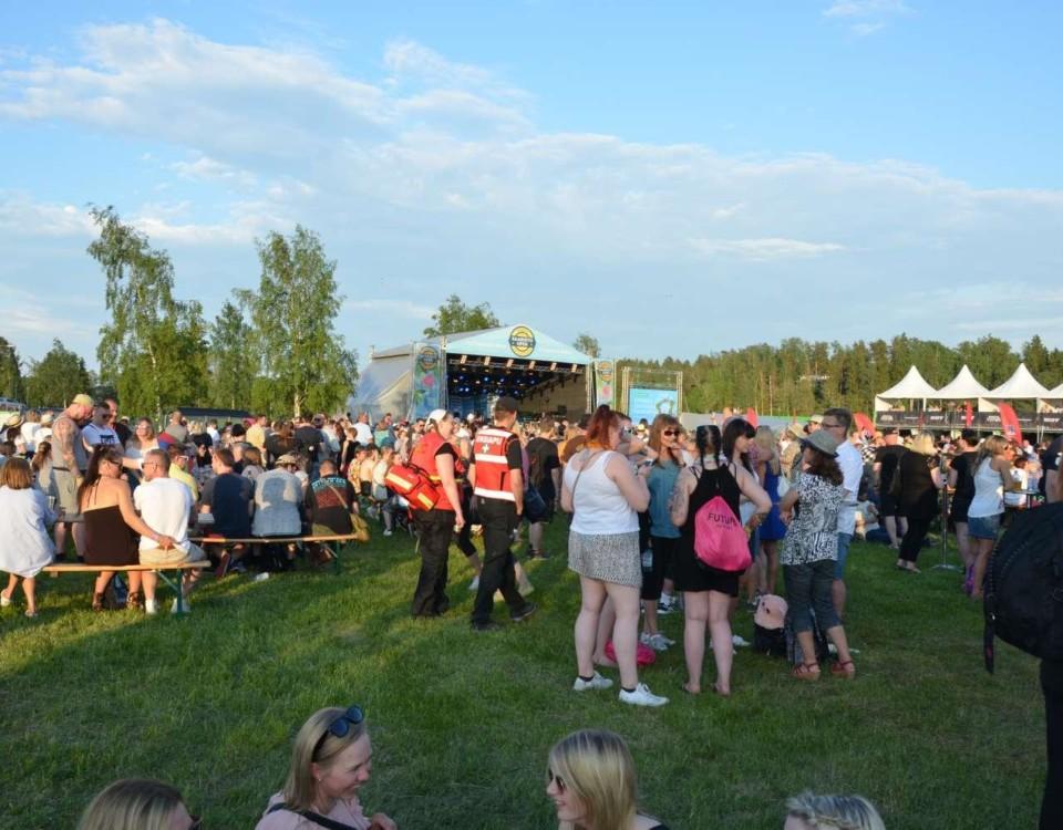 Människor på ett festivalområde i solsken.