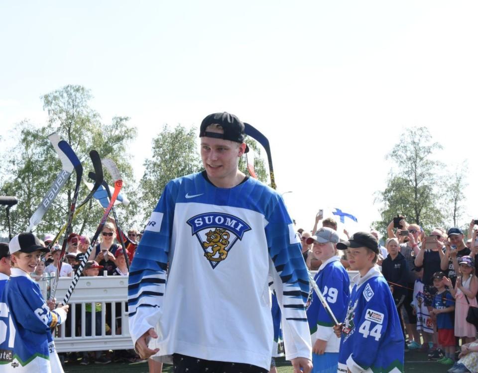 Ishockeyspelaren Kaapo Kakko iklädd Finlands vita spelskjorta stiger upp på scen på guldfesten i hans ära ordnad av Lundo kommun.