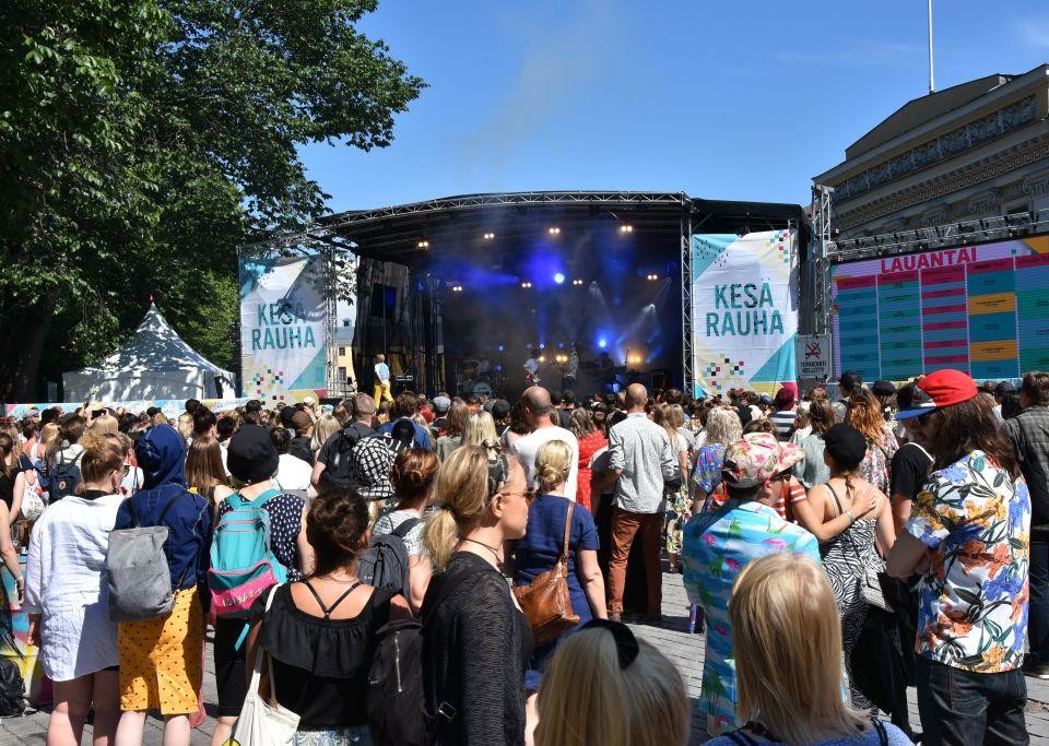 Ett människohav framför en festivalscen, solen lyser.