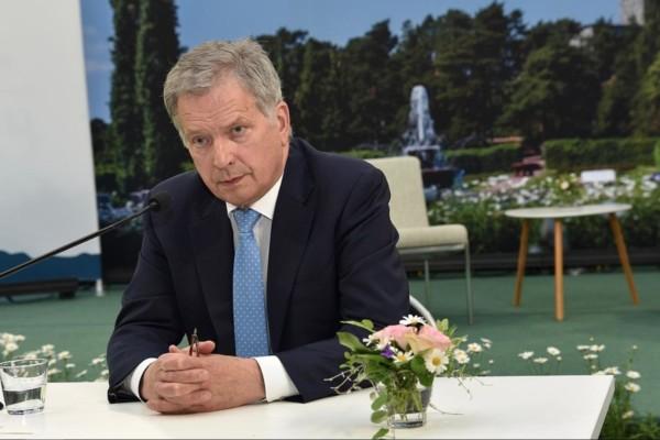 Finlands president sitter vid ett bord