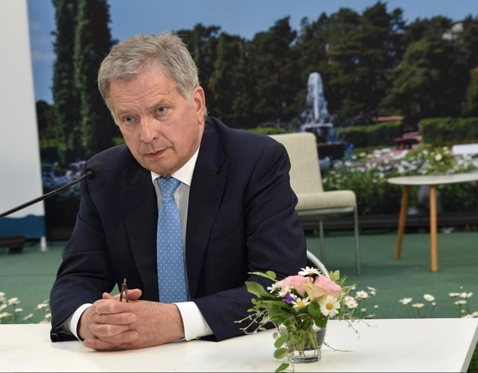 Finlands president sitter vid ett bord