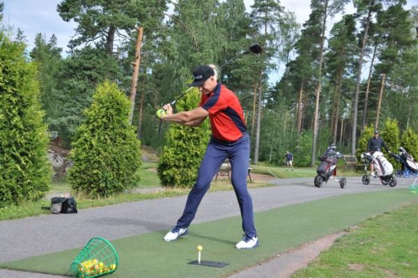 Golfaren Teemu Pitkänen slår ett golfslag på en golfbana i Nådendal.