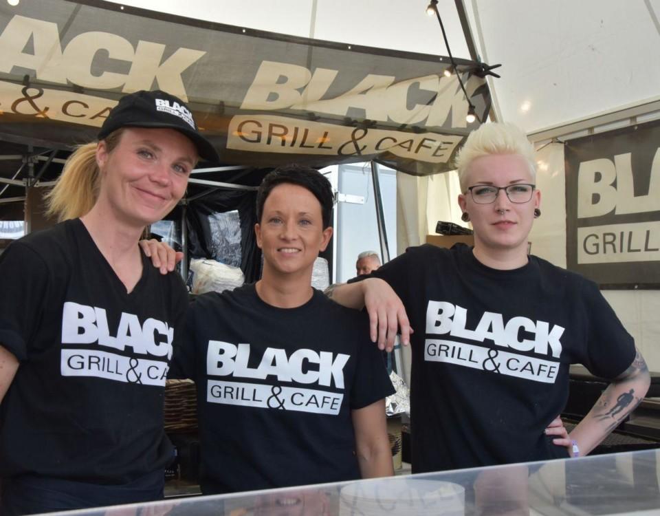 tre kvinnor i "Black bar and café"-t-skjortor.