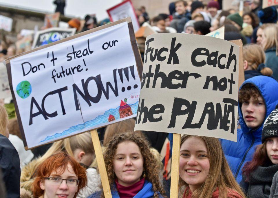 en grupp demonstranter och två skyltar med texterna "Don´t steal our future, act now" och "Fuck each other not the planet".