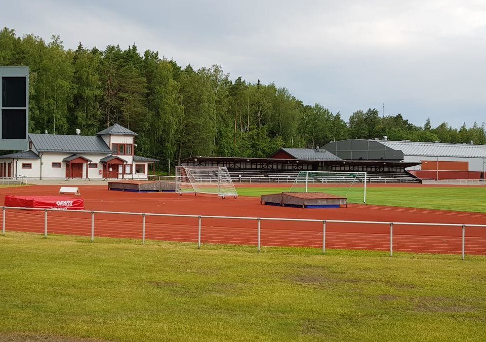 sportplan med fotobllsplan, läktare och löpbanor