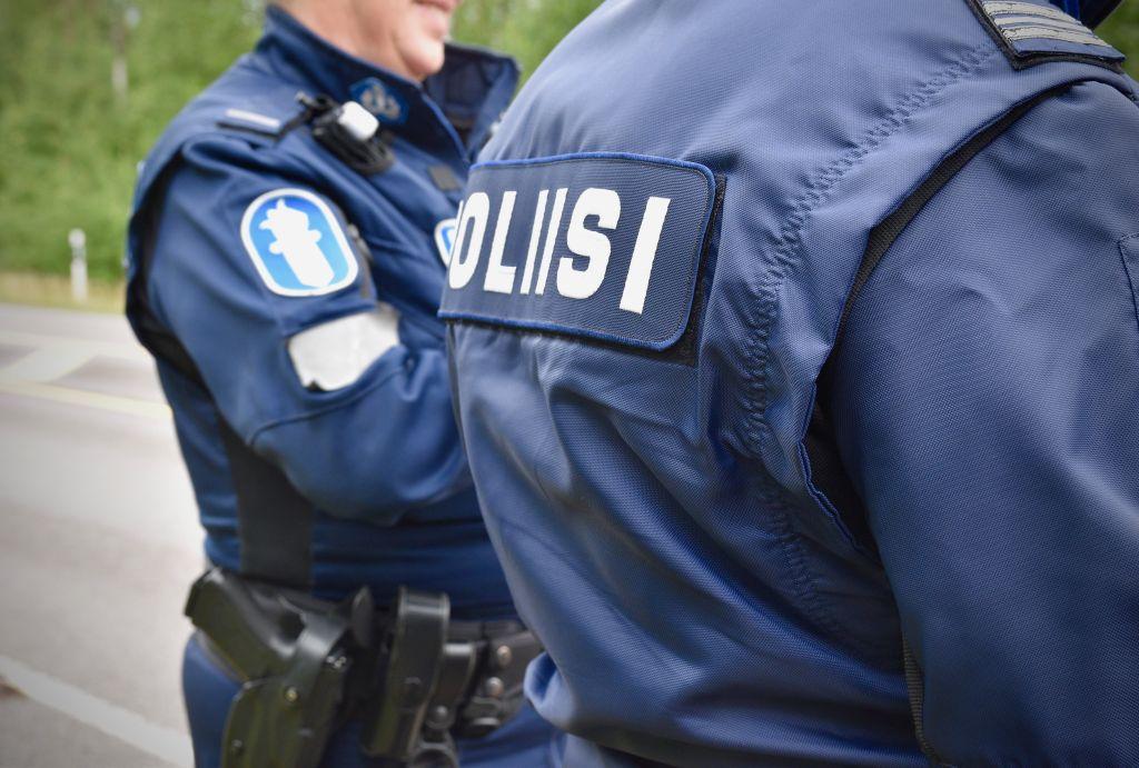 Övre kroppen av två polistjänstemän. Man ser inte personernas ansikten utan endast uniformerna med texten "Poliisi"