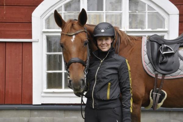 Häst och en ryttare som står på marken