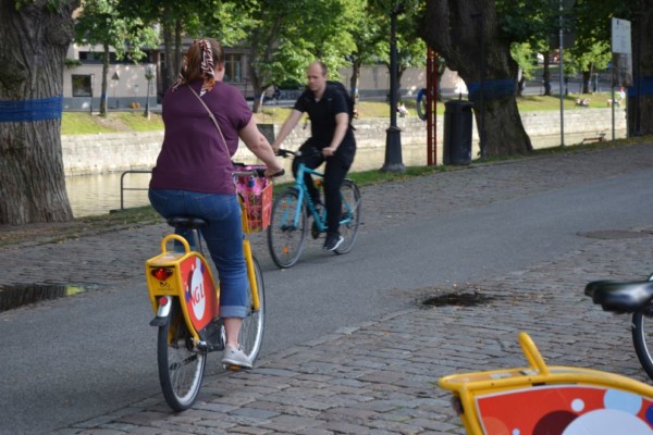 kvinna cyklar iväg på en stadscykel längs auraå