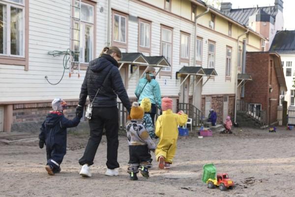 Vuxna med barn på en dagisgård.