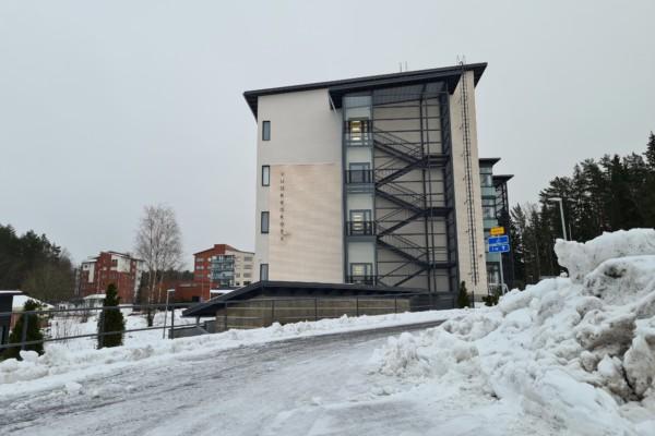 en hög byggnad vid slutet av en snöig väg