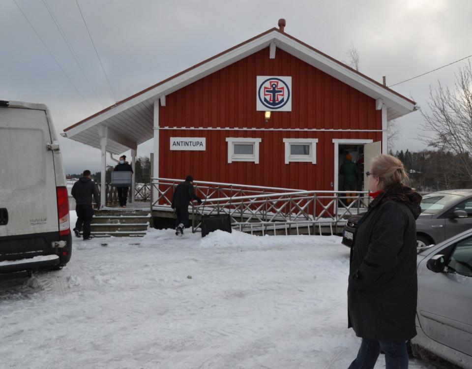 flyttkarlar tömmer en röd byggnad med vita knutar