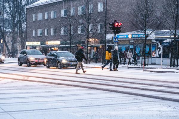 personer korsar väg i snöstorm