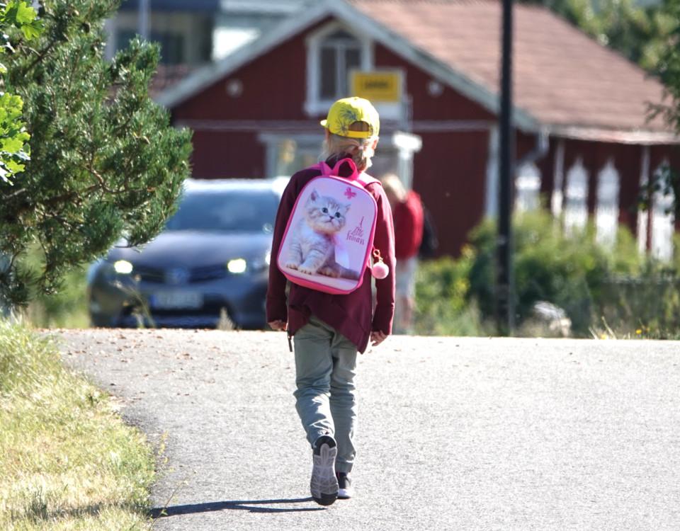 barn med gul skärmmössa och ryggsäck på ryggen