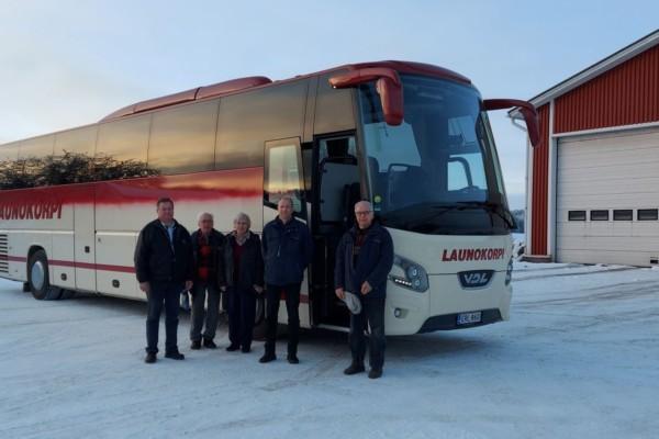 En turistbuss- Fem personer står bredvid den.