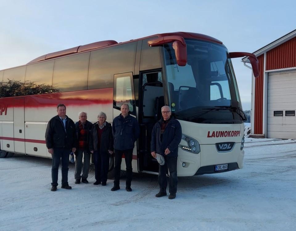 En turistbuss- Fem personer står bredvid den.