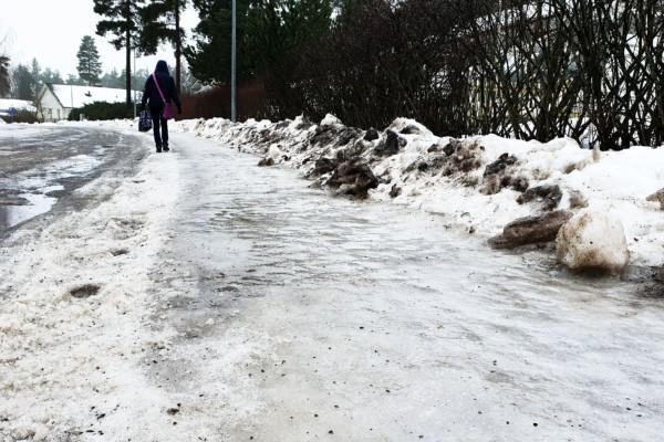 Kvinna som går på isbelagd trottoar.