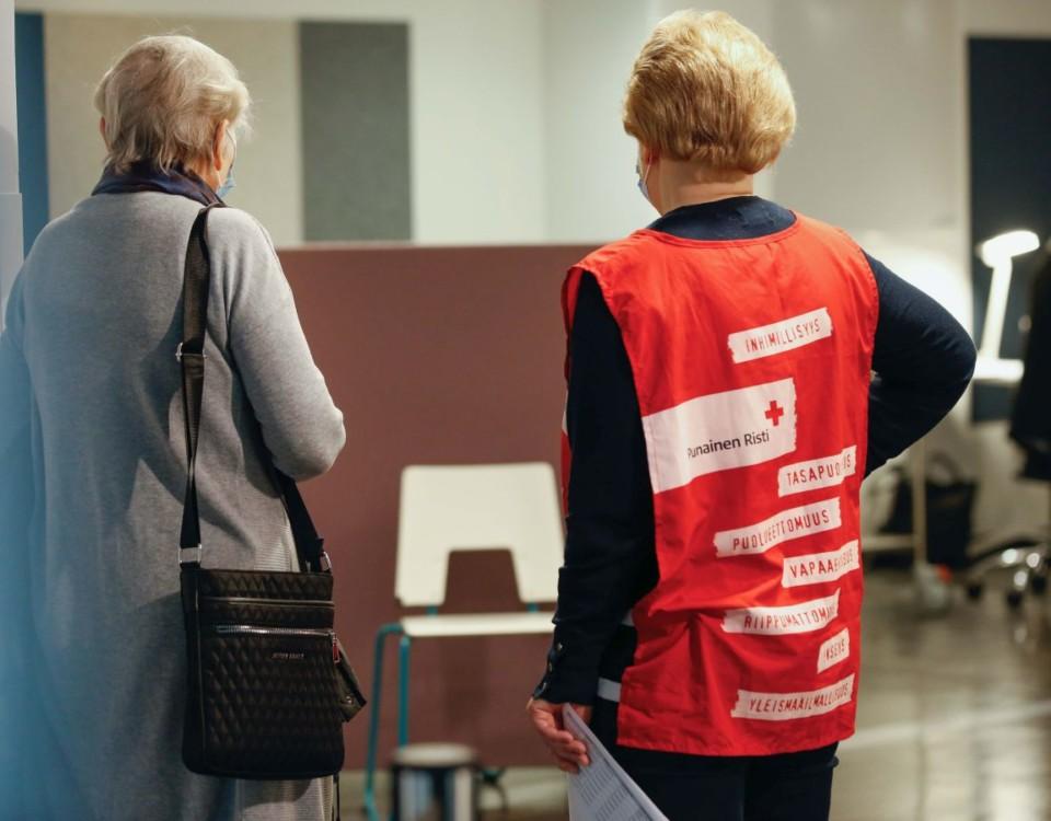 Frivillig från Röda Korset handleder kvinna