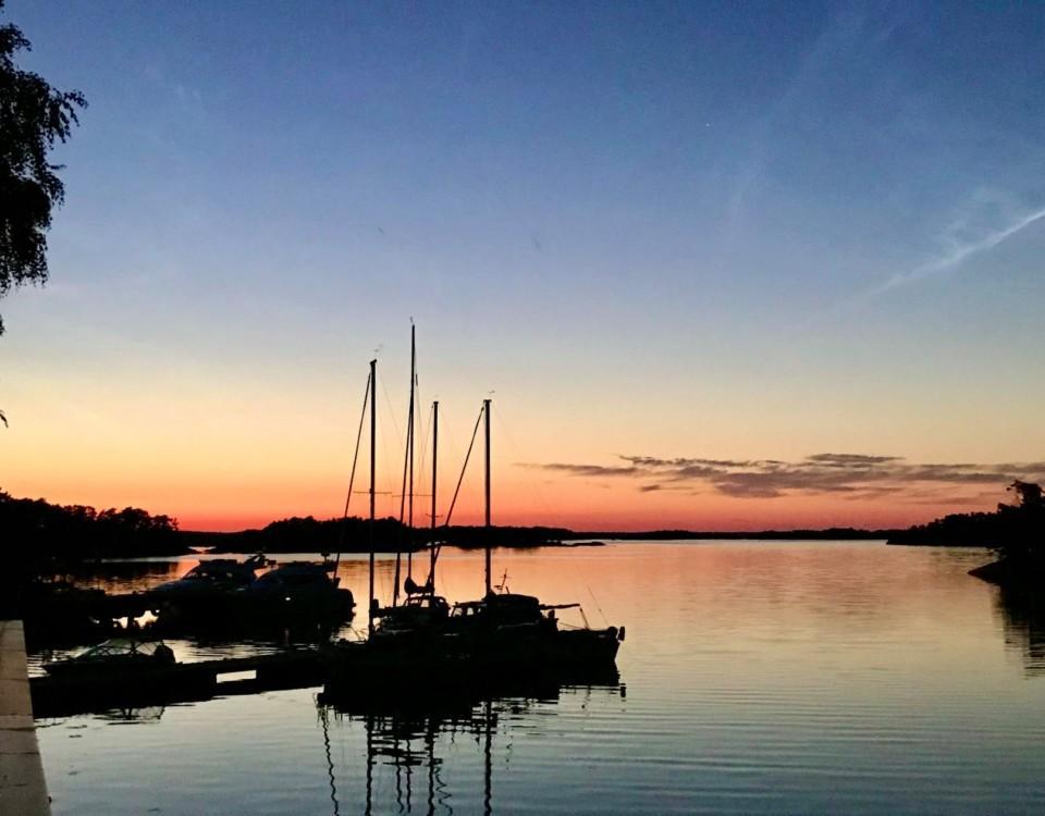 solnedgång över bryggor med båtar