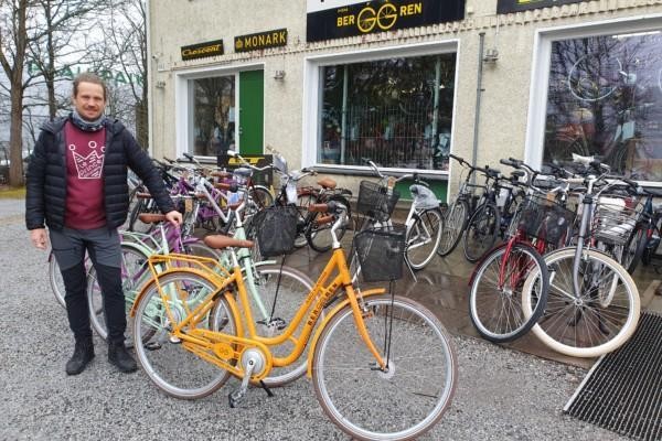 Man står med cyklar framför en cykelaffär.