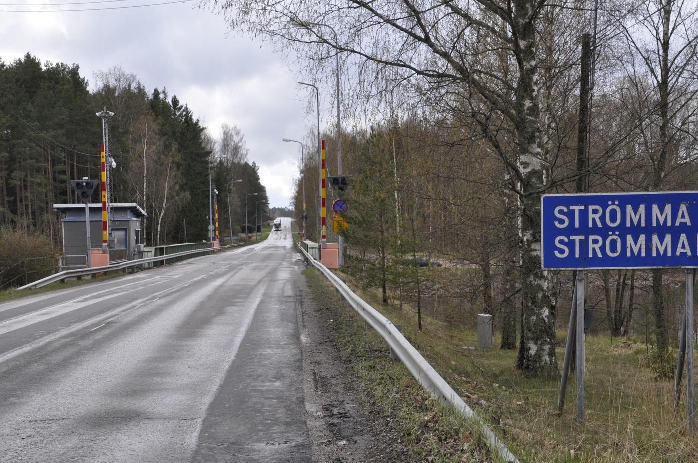 En bro med bommar. Skylt med texten Strömma