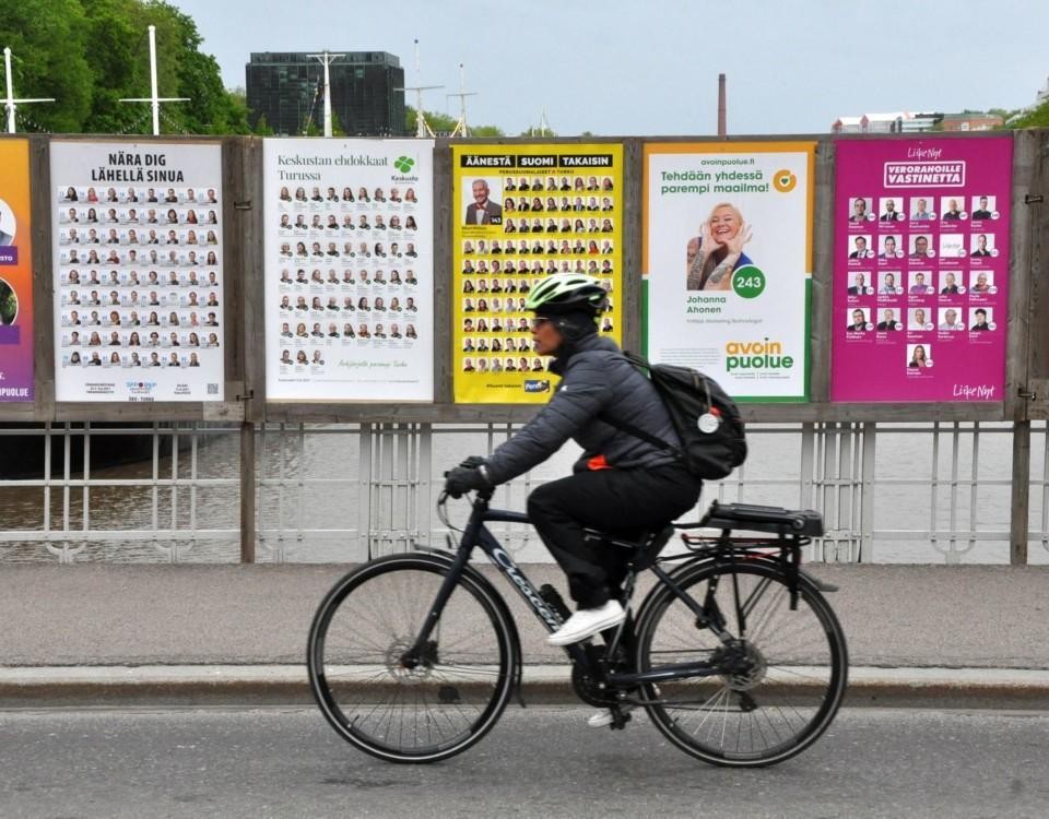 Cyklist passerar valplakat