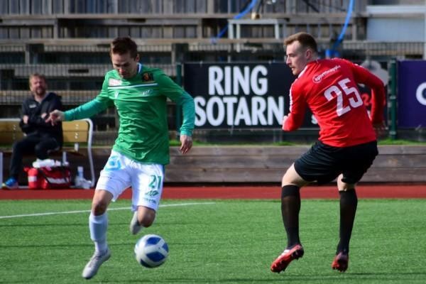 en fotbollsspelare i rött tittar efter bollen