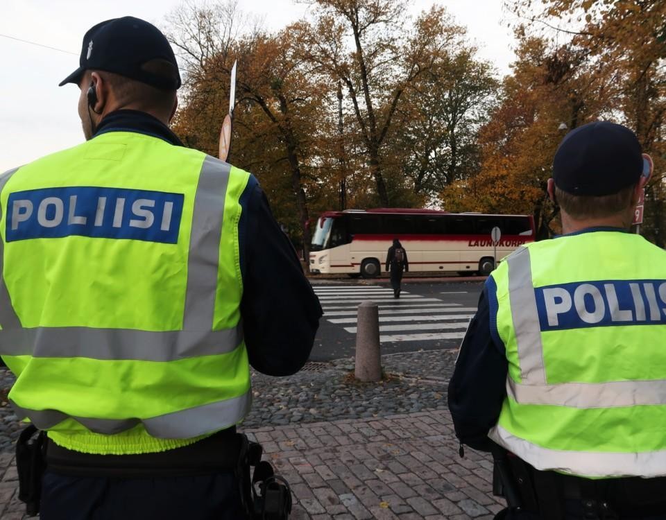 Ryggen av två poliser med neongulavästar.