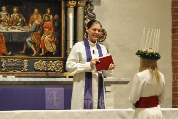 en kvinnlig präst vid altaret