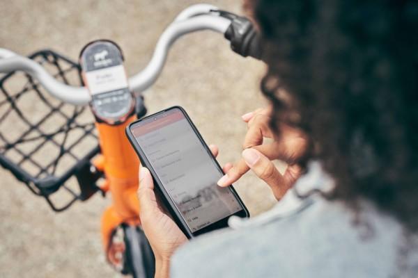 Person med cykel surfar på mobiltelefon