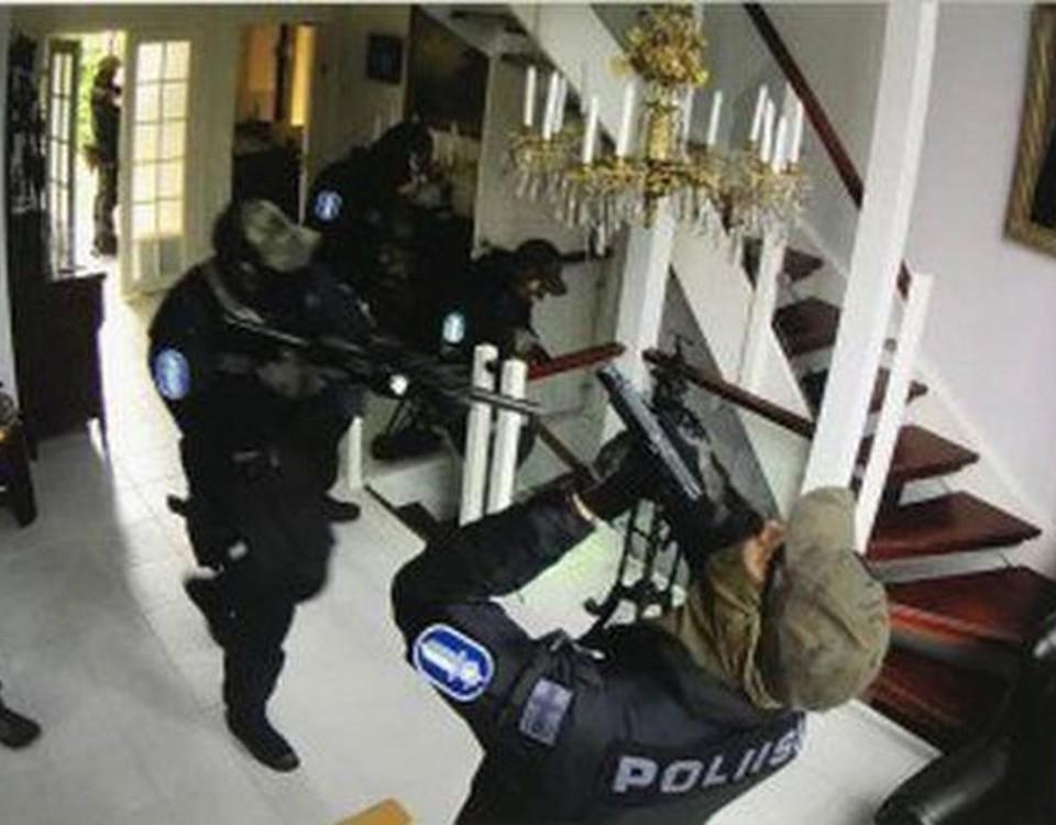 poliser med gevär i ett hus