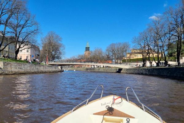 Bild från en båt på Aura å, med Domkyrkan längst bort och Biblioteksbron i förgrunden.