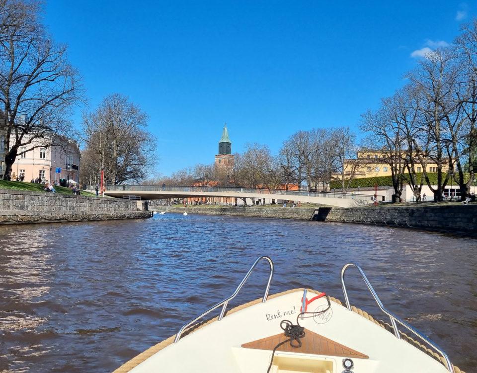 Bild från en båt på Aura å, med Domkyrkan längst bort och Biblioteksbron i förgrunden.