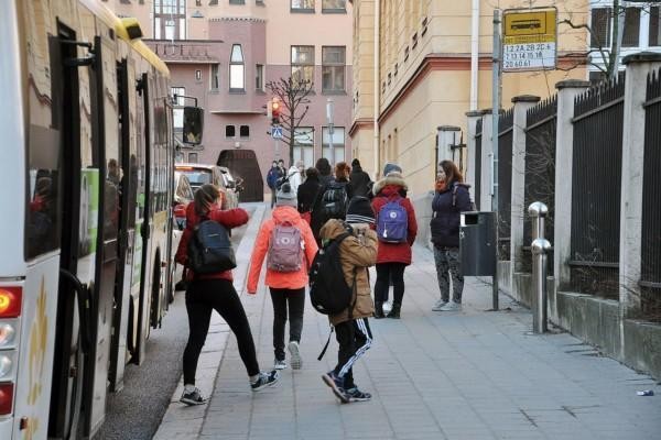 Barn stiger av buss vid hållplats i stadsmiljö