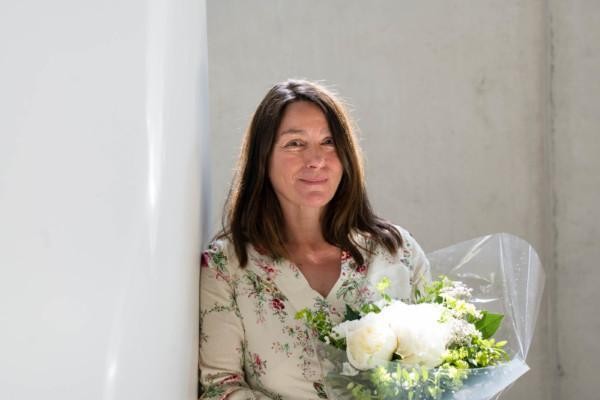 kvinna med stor blombukett, fotad i fint ljus