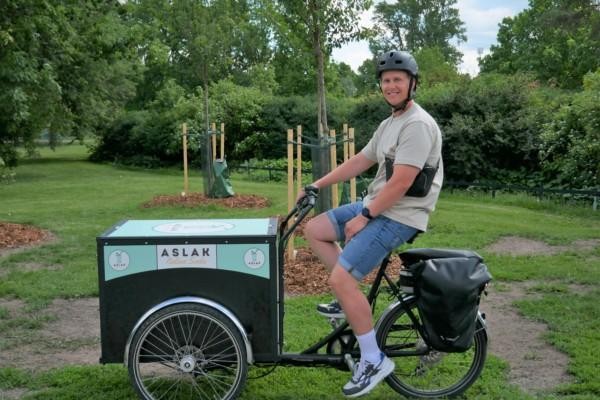 Man på cykel med låda.