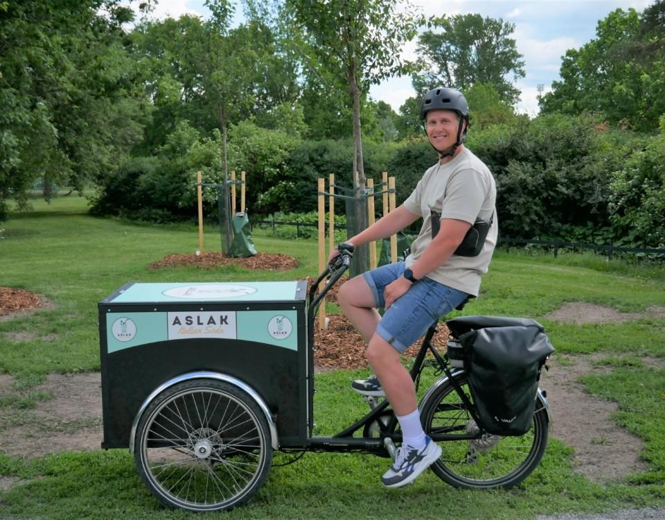 Man på cykel med låda.