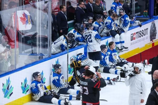 bersvikna ishockeyspelare sitter lutade mot sargkanten