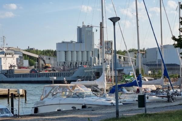 segelbåtar med stort fartyg och fabrik i bakgrunden