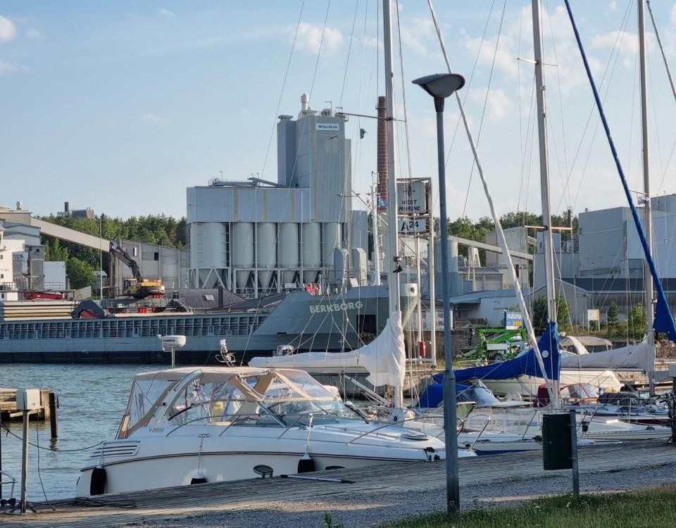 segelbåtar med stort fartyg och fabrik i bakgrunden